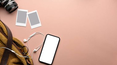 Fotokopi alanı, akıllı telefon, fotoğraf kartı çerçevesi, kamera, çanta ve kulaklığı olan pembe tablo üst görünümü, kırpma yolu