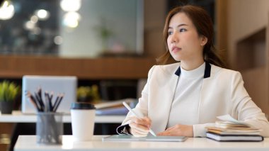 Dijital tabletle çalışırken ileriye bakan güzel girişimcinin yarım boy portresi 