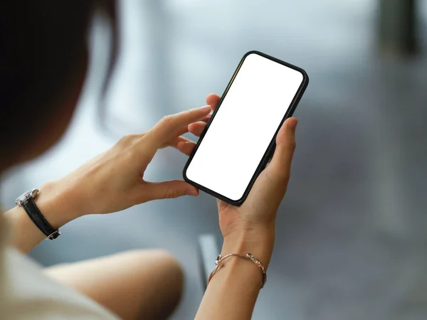 Over shoulder closeup view of female hands using mock-up smartphone include clipping path screen