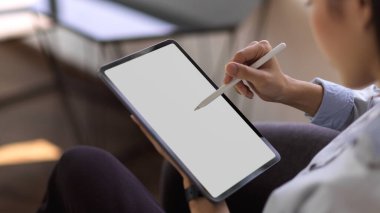 Kafeteryada dinlenirken ekranı taklit eden dijital tablet kullanan iş kadınının yan görünümü