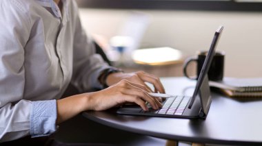 Toplantı odasındaki tablet klavyeye yazı yazan işadamlarının yan görünümü