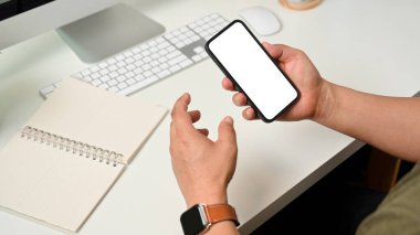 Akıllı telefonu tutan erkeğin yan görünümü çalışma alanındaki yol ekranını kırpmayı içerir 