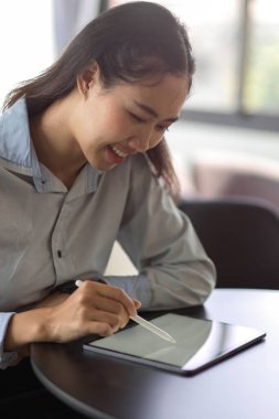 Genç kadın projesinde çalışırken boş ekran dijital tabletini taklit ediyor. 