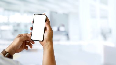 Bir adam elele tutuşup, arka planda bulanık bir şekilde akıllı telefondan kameraya sahte görüntüler gösteriyor.
