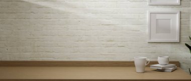 3D görüntüleme, kupa, kitap ve kopya alanı ile basit çalışma alanı tuğla duvar zemininde çerçeve ile ahşap masa, 3D illüstrasyon 