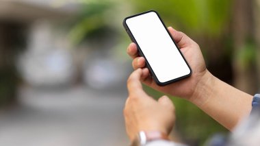 Akıllı telefon kullanan erkek ellerinin görüntüsünü kapatma yolu ekranını bulanık arka planda kırpma içerir