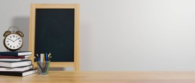 Education concept, 3D rendering, school elements on the table with books, stationery, alarm clock, chalk board, and copy space, 3D illustration