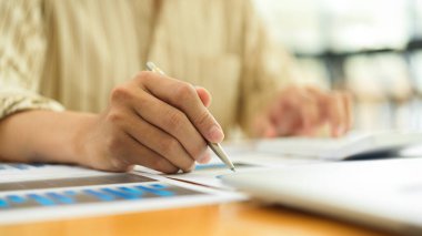 İşadamı elinin kağıt işleriyle uğraşırken ve ofis masasında dizüstü bilgisayarla görüntüsünü kapat. 