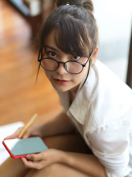 Porträtt Ung Kvinna Med Glasögon Tittar Kameran När Använder Smartphone — Stockfoto