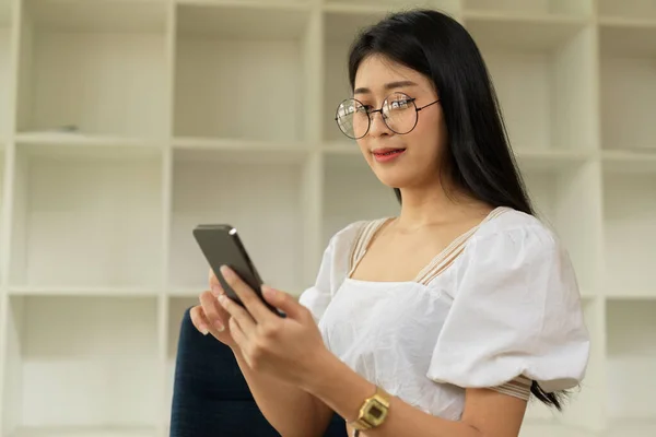 Retrato Jovem Sexo Feminino Com Óculos Usando Smartphone Enquanto Sentado — Fotografia de Stock