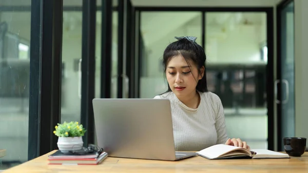 Giovane Studentessa Attiva Leggere Libro Fare Compiti Con Computer Portatile — Foto Stock