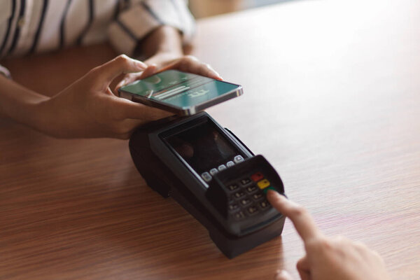 Payment by payment terminal on the wooden desk