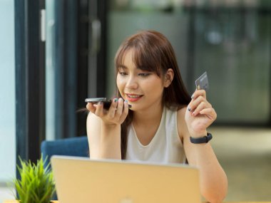 Kredi kartı servisi ile kadın bağlantısı, kredi kartı ile telefon görüşmesi yapan kadın, online alışveriş ödemesi