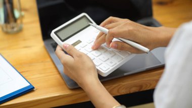 Bir sonraki projenin iş bütçesini hesaplamak için hesap makinesi kullanarak kadın ellerini kapat