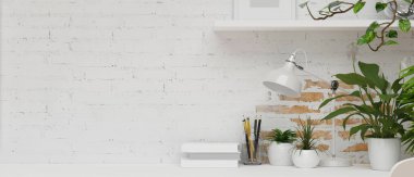 Beyaz dekorasyonlu, masa lambası, kitap, kırtasiye, raf, boş çerçeve ve ev bitkileriyle bembeyaz tuğla duvarlı en az çatı katı dairesi, 3D görüntüleme, 3D resimleme