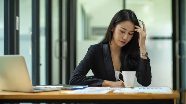 Businesswoman feeling stressed out from work, manager looking at financial report on table at office