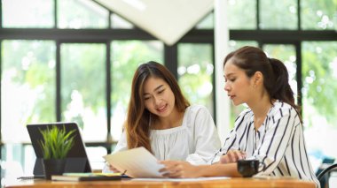 İki iş adamı birlikte çalışmayı planlıyor, dijital pazarlama fikirlerini konuşuyor, iş kampanyasını anlatıyor
