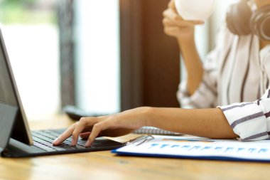 Kahve molası sırasında taşınabilir tablet kullanan, kahve içen, kahve içen bir kadın.