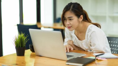 Laptop kullanan güzel Asyalı kadın, laptop ekranına bak, çalışan e-postaları oku