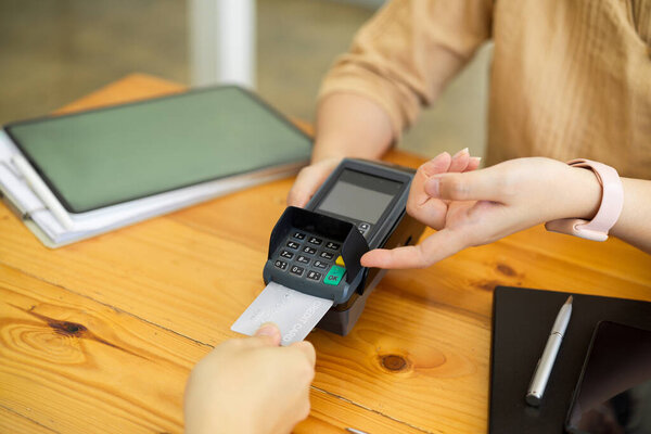 Customer paying by credit card, insert credit card into payment machine, POS terminal
