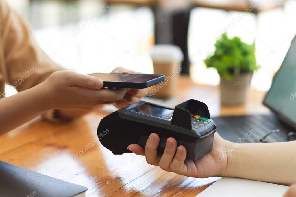 Closeup, The customer paying drinking bills by using smartphone scan QR code on payment terminal at coffee shop, online payment, money transaction