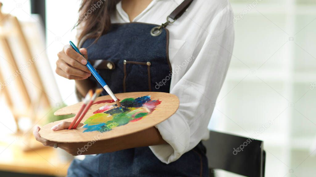 Artist palette closeup, female artist mixed oil colour on art palette, creative art, inspiration painter