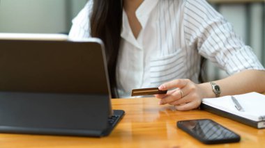 İnternet üzerinden ödeme, kredi kartı ve internet bankacılığı yoluyla ödeme yapmak için tablet ve kredi kartı kullanan kadın tüketici