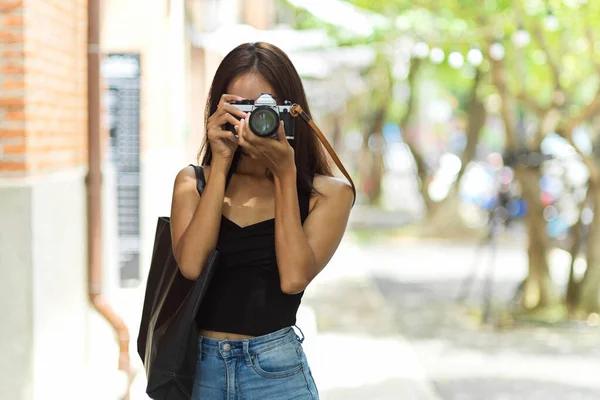 ヴィンテージカメラで旧市街の写真を撮る女性観光客の写真 休日をキャプチャ ヒップスター趣味と活動 — ストック写真