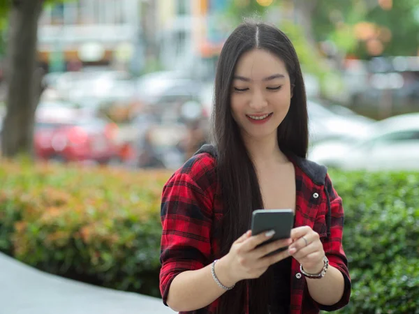 Neşeli Asyalı Genç Kadın Akıllı Telefon Kullanıyor Arkadaşlarıyla Sohbet Ediyor — Stok fotoğraf