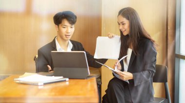 İş arkadaşları konferans odasında dijital tablet aracılığıyla müşteriyle görüntülü görüşme yapıyorlar.