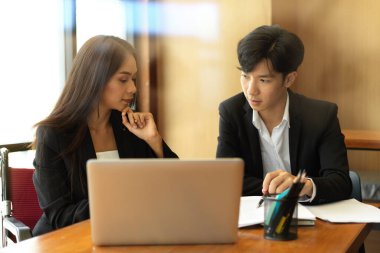 İş kadını ve işadamı ofiste konuşuyor ve iş görüşüyorlar. İş arkadaşları proje üzerinde birlikte çalışıyorlar.