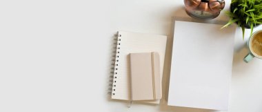 Boş kitap kapağı, günlük, not defterleri, kitapçık ve beyaz arkaplanda süslemeleri olan metin veya ürün sergisi için maket alanı. Üst görünüm 
