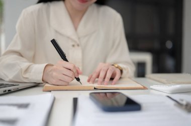 Ofiste çalışan kadın bir ofis çalışanı ya da katip, ofiste çalışırken dolma kalemle deftere yazı yazıyor. Sekreter ya da Yazman, Modern şirket..