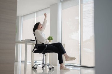 Kadın bir ofis çalışanı ya da iş kadını boş bir ofiste koluyla döner sandalyeye oturmuş. Bekleme ya da Dinlenme, Şirket işi, modern şirket.