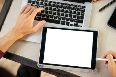 Beton masada otururken dizüstü bilgisayardaki beyaz ekran tabletine el ele tutuşup Stylus 'u göster. Çizim, yazma, öğrenim ya da dışarıda çalışma.