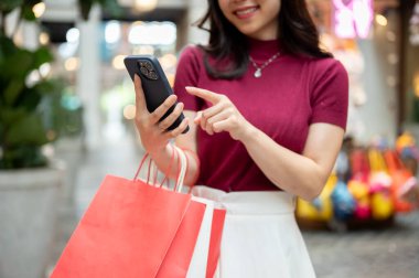 Alışveriş torbası tutan kadın müşteriyi markette ya da alışveriş merkezinde beklerken telefona bakar gibi kapat. Ödeme günü tanıtımı, seyahat gezisi, turistik yerler..
