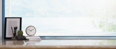 Geniş pencerenin altındaki parlak mermer masa üzerinde kaktüs ve fotoğraf çerçeveli kitapların üzerinde bir saat. çalışma köşesi, 3D görüntüleme, 3d illüstrasyon.