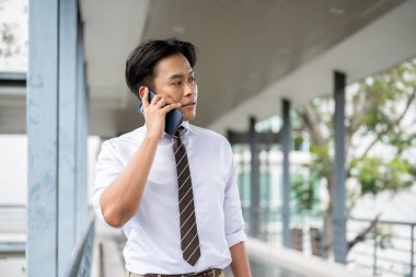 İş adamı ya da ofis çalışanı telefonda konuşuyor ve yaya köprüsünde yürürken yana bakıyor. Git ya da işi bırak, modern şirket işleri..