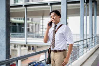 İş adamı ya da ofis çalışanı yaya köprüsünde tek eliyle telefonla konuşuyor. Git ya da işi bırak, modern şirket işleri..