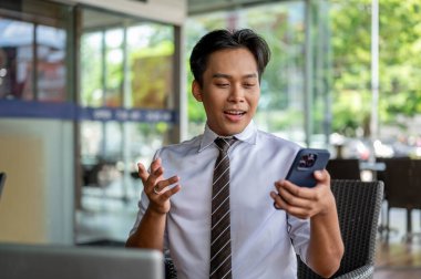 Erkek ofis çalışanı hoparlörden konuşuyor ya da bir kafede ya da kahve dükkanında otururken video görüşmesi sırasında açıklama yapıyor. İş adamı ya da Maaşçı, dışarıda çalışıyor..