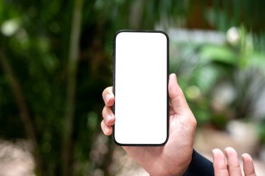 Bir adamın elini tutarken ve dışarıdayken beyaz ekran akıllı telefonu gösterirken. Haber ve güncelleme, Reklamcılık, Çevrimiçi Toplum.