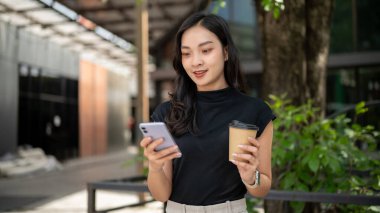 Asyalı üniversite öğrencisi ya da elinde kahve tutan kadın ofis çalışanı bir kafede ya da bahçede telefona bakıyor. Fırlatma molası, Günlük hayat, Dışarıdaki Dinlenme.