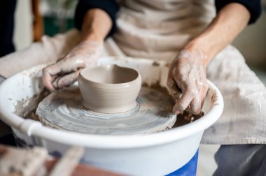 Çömlekçiyi sınıfta veya stüdyoda çay demlemek için kil kasesine tel makası kullanarak kapat. Seramik Yapım, El yapımı Ürün, Sanat Atölyesi.