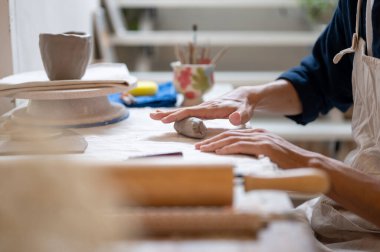 Sınıfta ya da stüdyoda, çömlek sanatçısının eline kil kupanın kulpunu dökerken yaklaş. Seramik Yapım, El yapımı Ürün, Sanat Atölyesi.