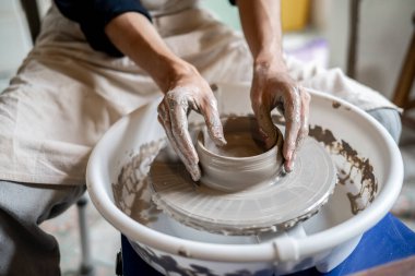 Çanak çömlek sanatçılarının elleri bir sınıfta veya stüdyoda dönen çarkta kilden kaseye dönüşür. Seramik Yapım, El yapımı Ürün, Sanat Atölyesi.