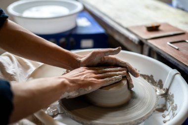 Çömlek sanatçılarının ellerini kapayın. Sınıfta ya da stüdyoda dönen çarklar üzerine kilden kase yapın. Seramik Yapım, El yapımı Ürün, Sanat Atölyesi.