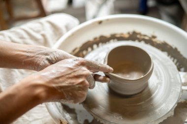 Çömlek sanatçısını kapatın. Sınıfta ya da stüdyoda dönen tekerlek üzerinde kil çay demleme kasesi yapıyor. Seramik Yapım, El yapımı Ürün, Sanat Atölyesi.