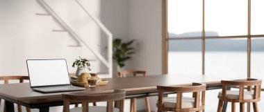 Beyaz ekran dizüstü bilgisayar ahşap yemek masasında ve merdivenlerin yanındaki modern ev ya da ofis binasında. Konforlu iç mekan, 3D tasarım, 3B Görüntü.