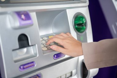 Bir kadının elini ATM 'nin tuş takımına koyup para çekmek ya da işlem yapmak için şifre numarasını giriyoruz. Seyahat kartı, Banka Reklamcılığı.