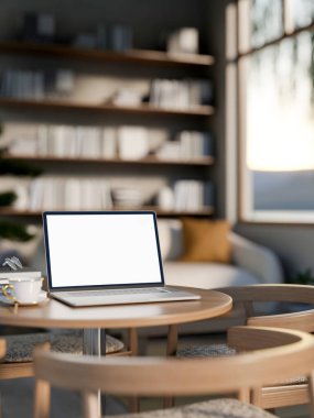 Boş ekran dizüstü bilgisayar ve çay fincanı, güneş ışığında oturma odasında, koltukları ve kitaplığı olan ahşap masanın üzerinde. Çalışma ya da Çalışma, 3B Hazırlama, 3B Resim.